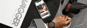 Top view of a stylish man with headphones, smartphone, and swagger magazine on a round table.